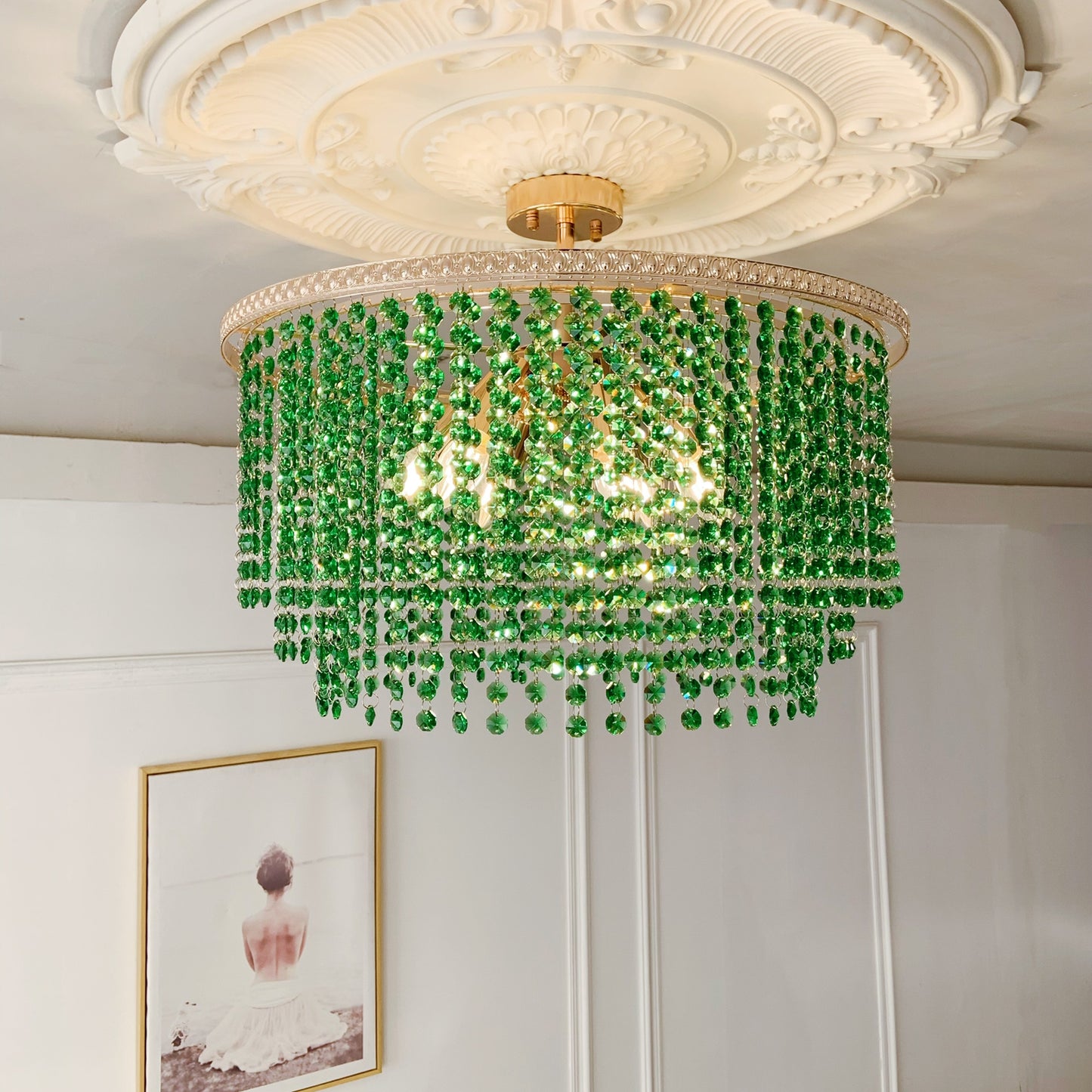 Green beaded chandelier hanging from a decorative ceiling fixture.