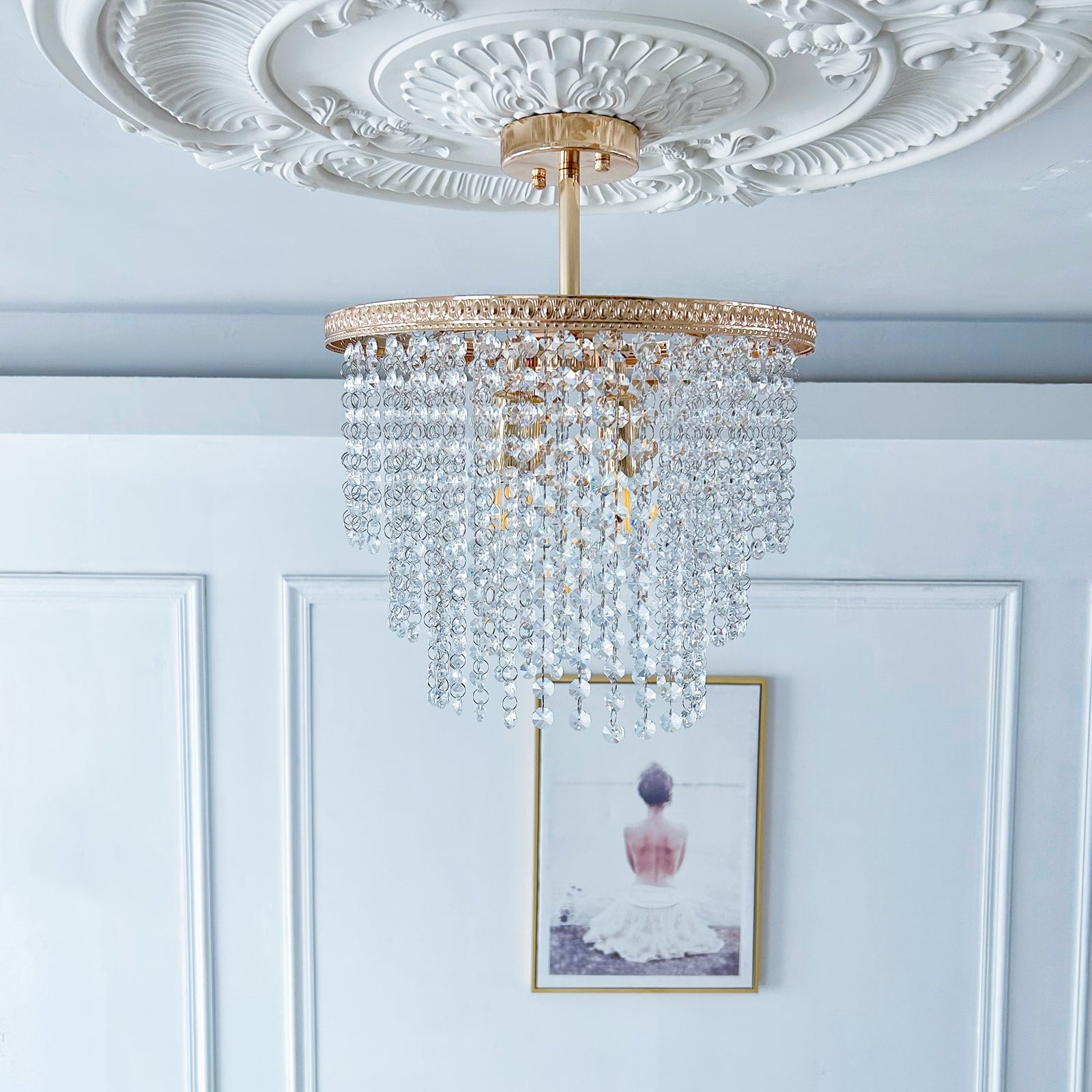 Gold crystal chandelier in elegant bedroom with warm ambient lighting