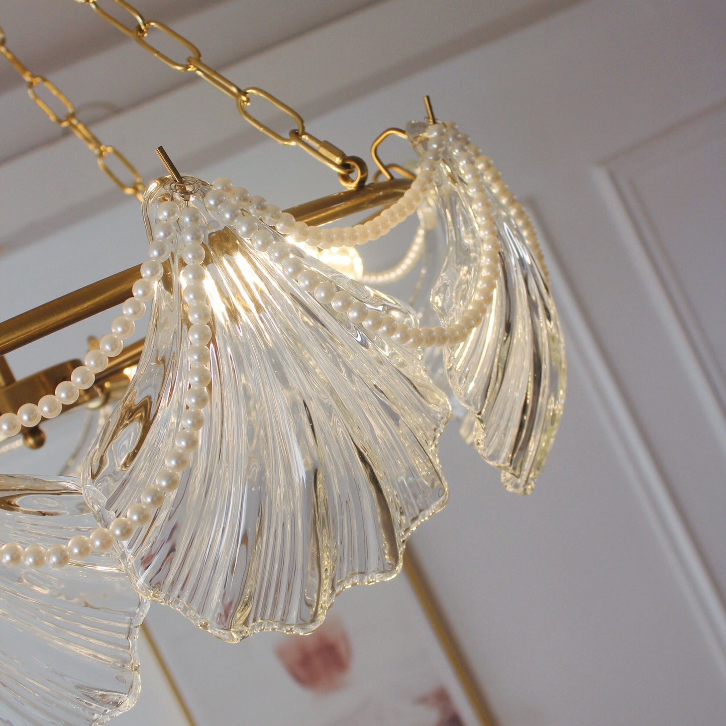 Close-up of a decorative chandelier with gold chain and clear glass elements.