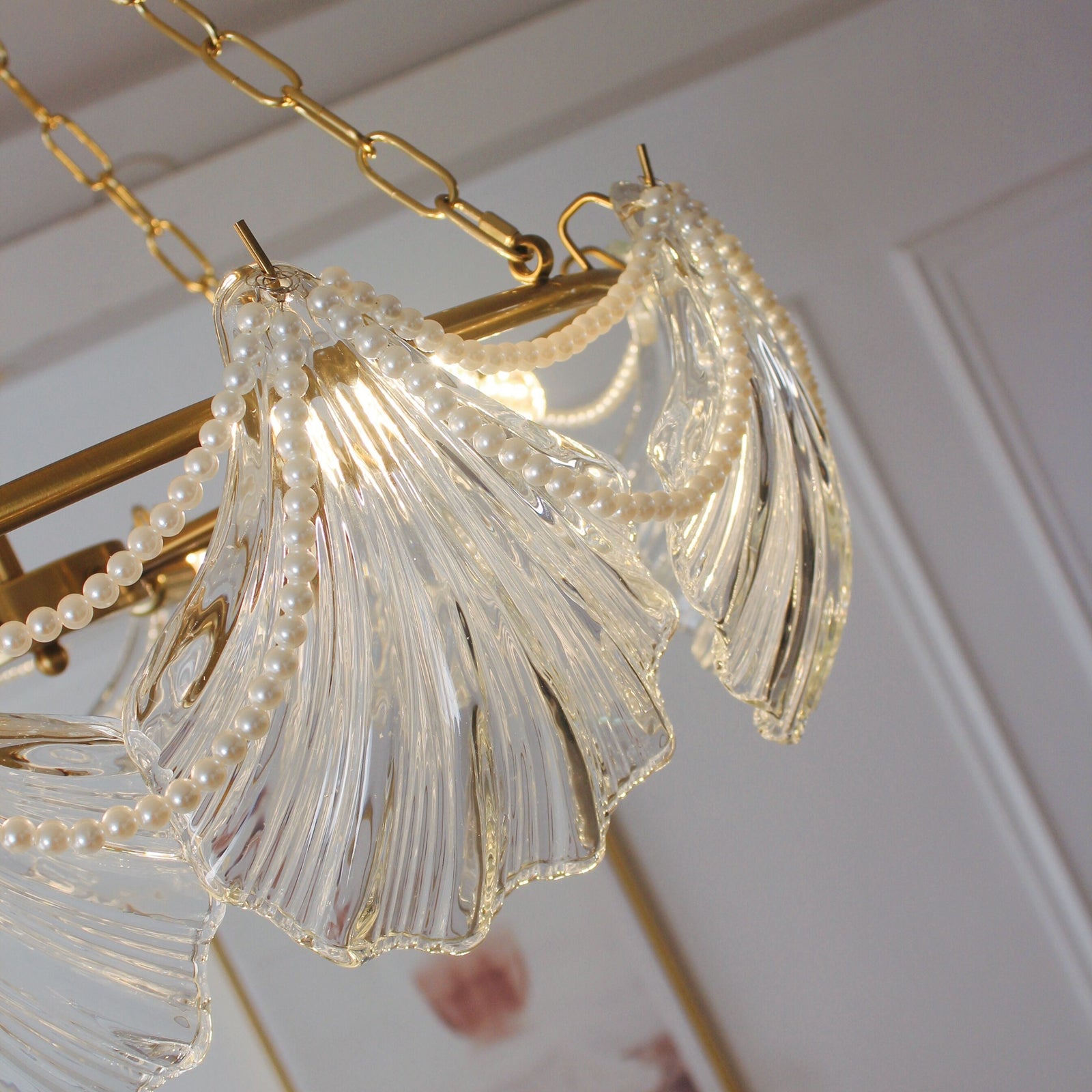 Close-up of a decorative chandelier with gold chain and clear glass elements.