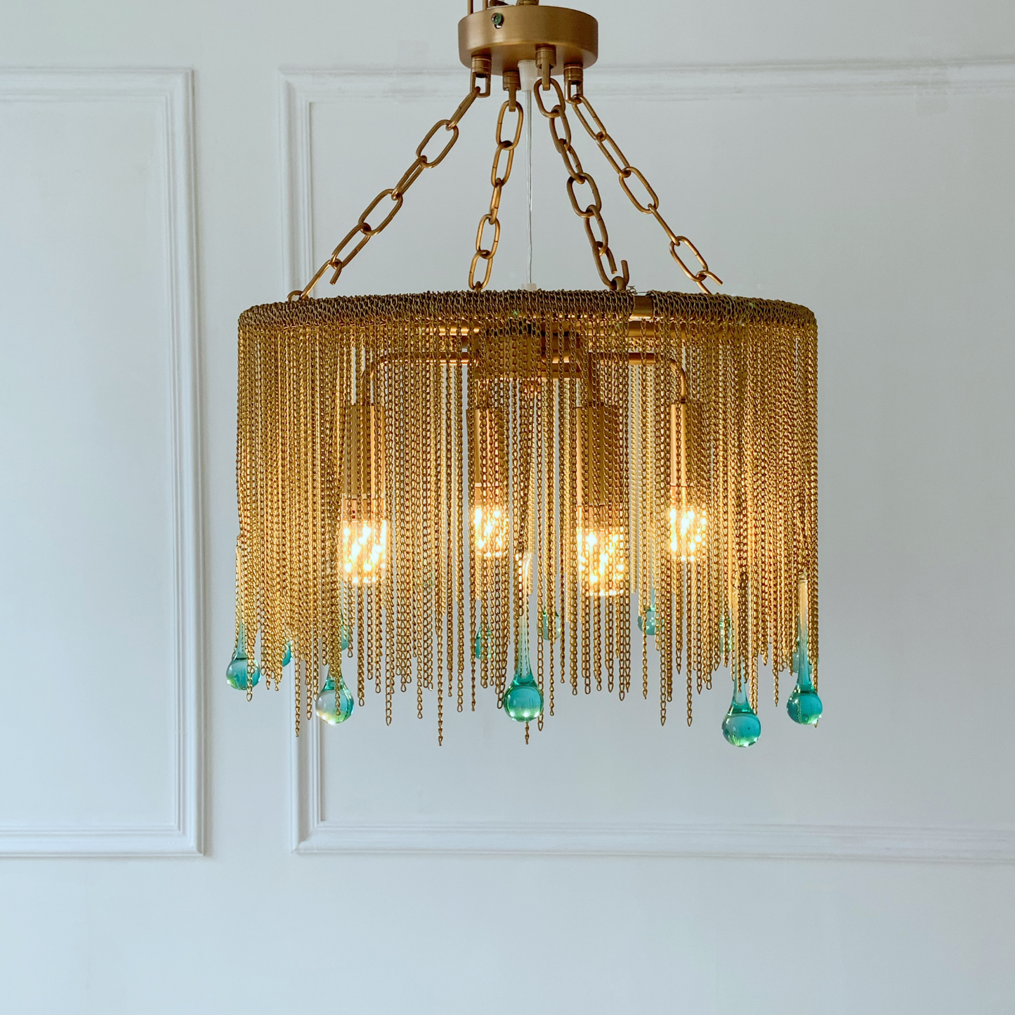 Antique brass chandelier with blue crystal drops creating elegant lighting in entryway