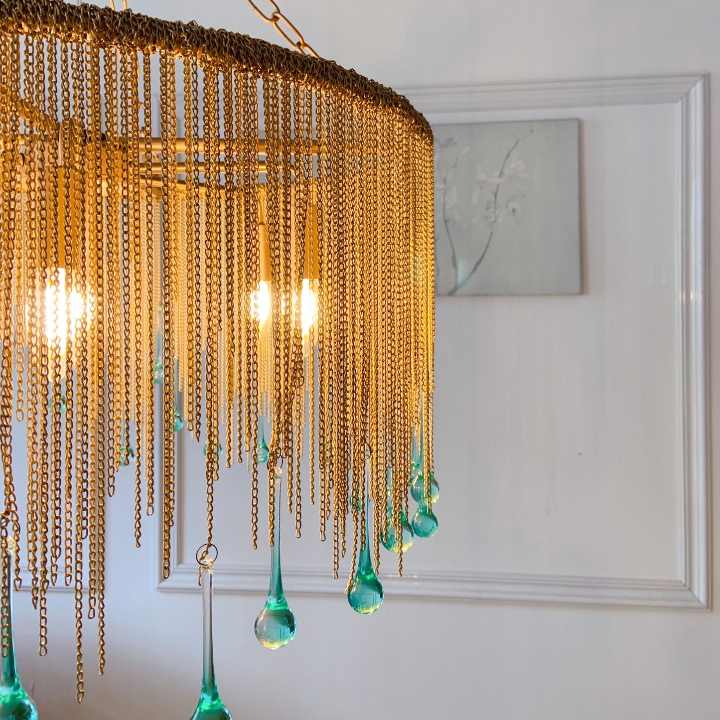 Chain chandelier close up showing handcrafted brass links and teardrop crystal details