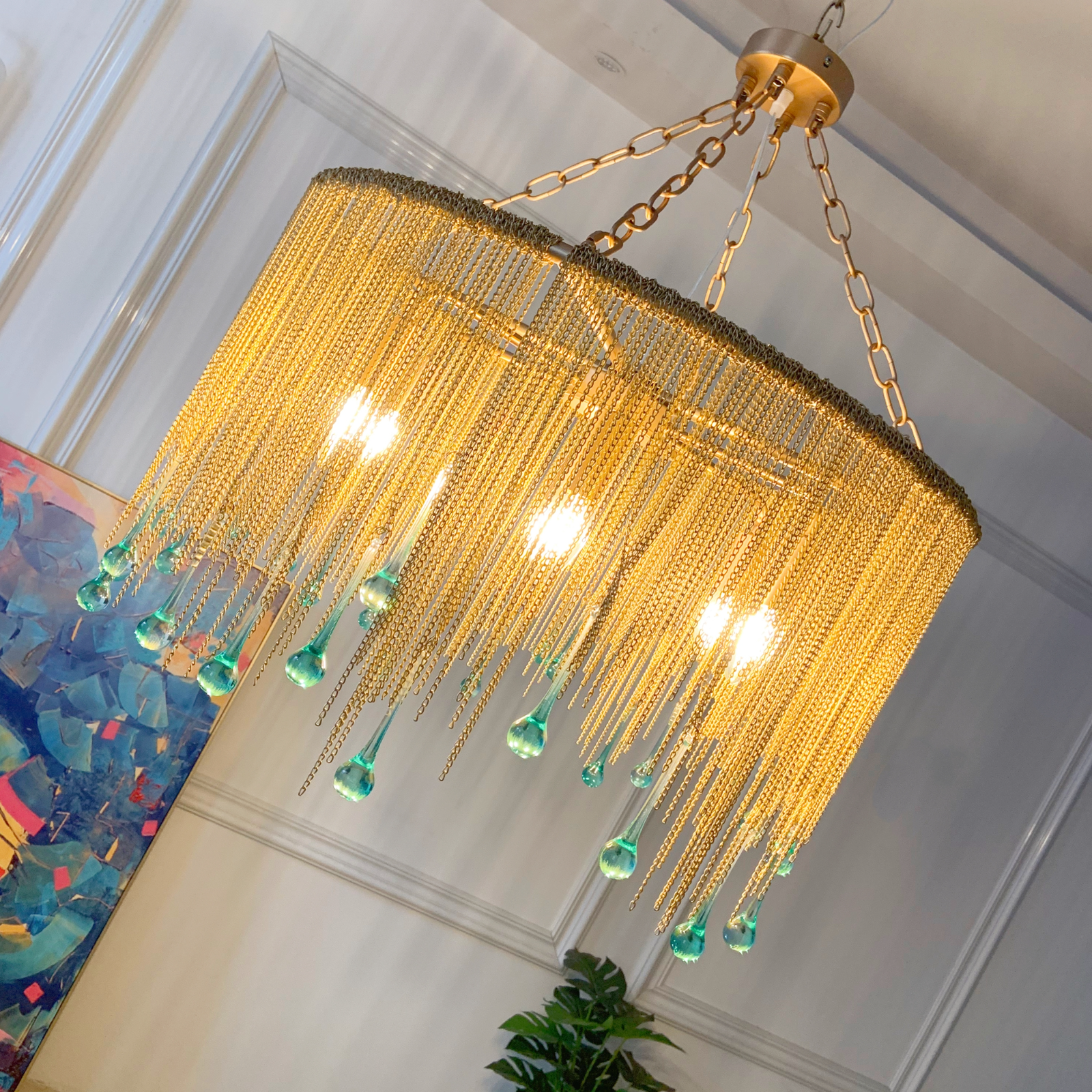 Brass chandelier with cascading chains and crystal accents creating statement lighting in entryway