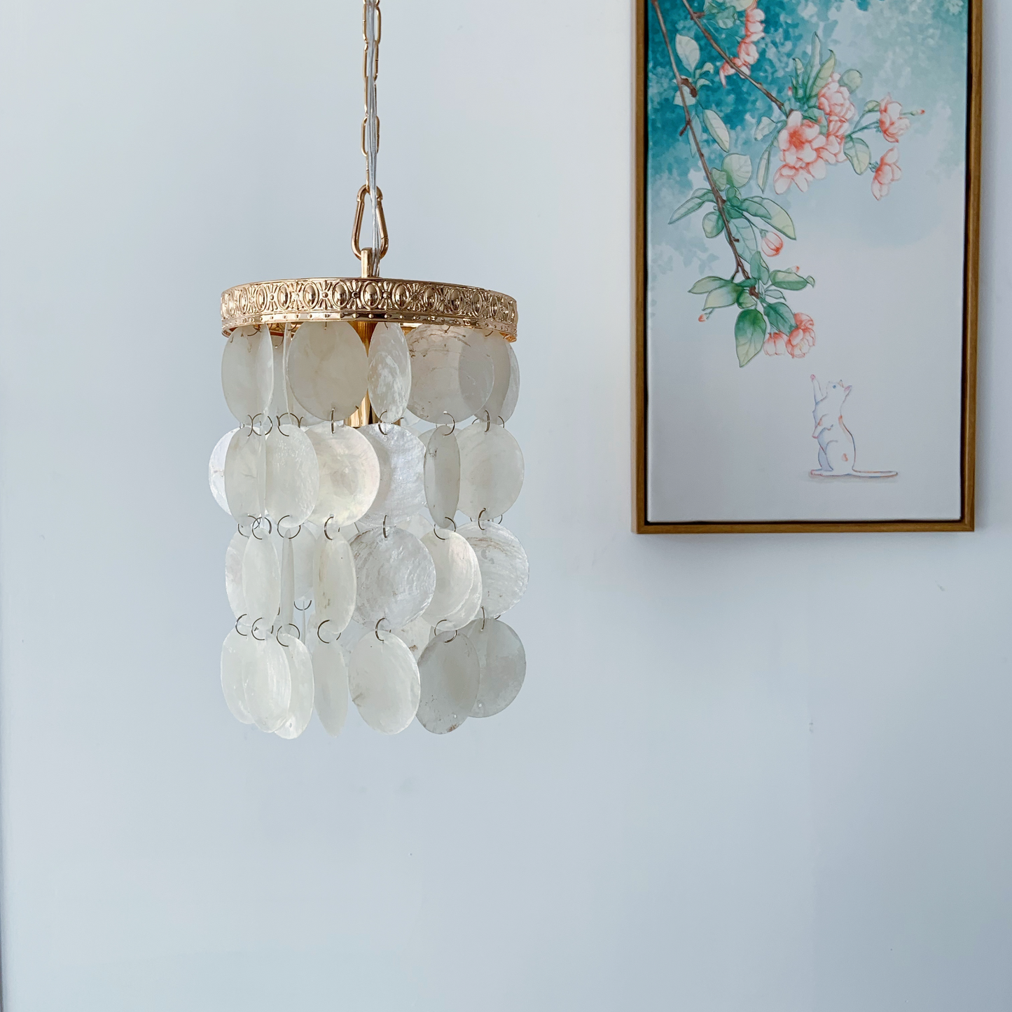 Cafe pendant light with ocean blue capiz shells creating warm ambiance over coffee bar