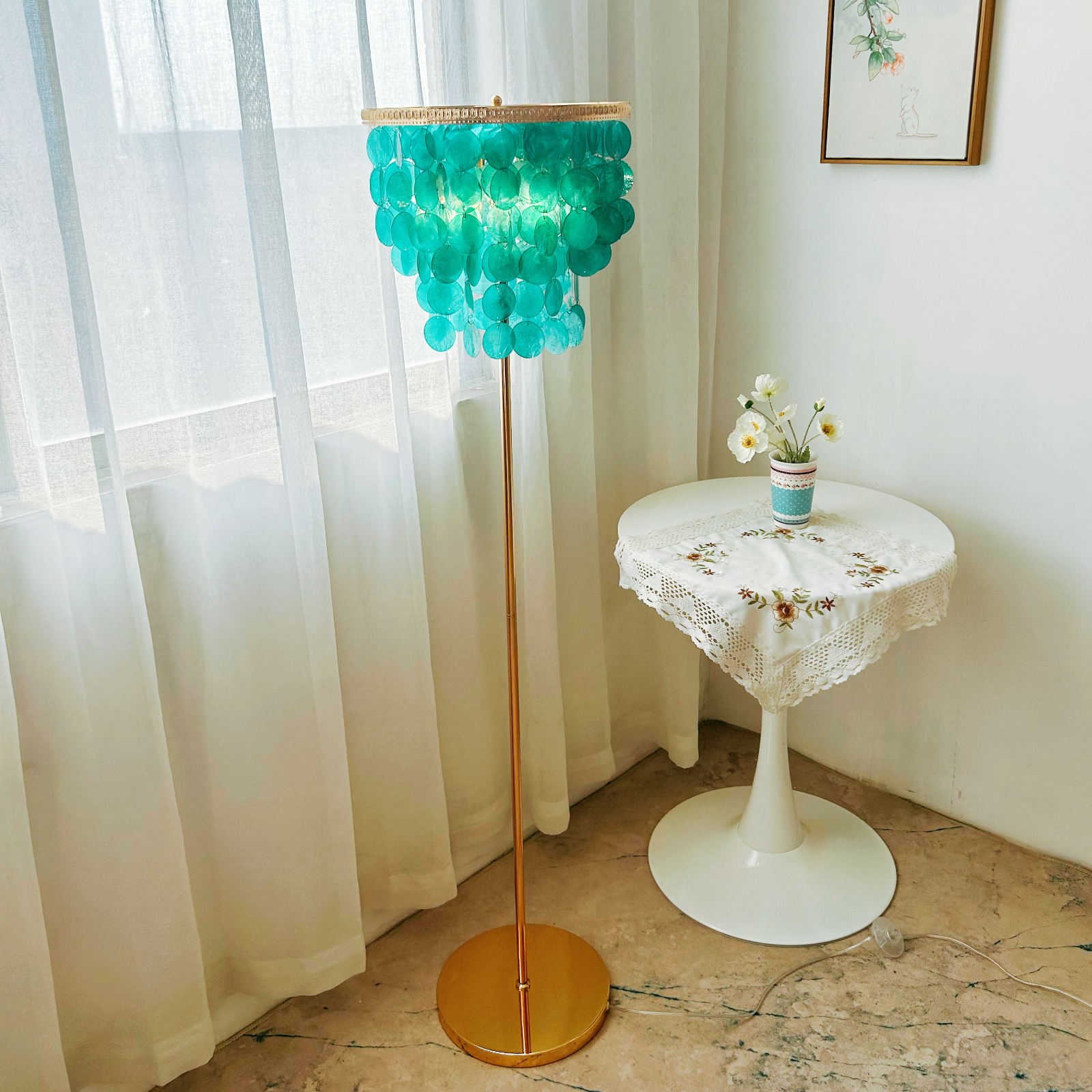 Handcrafted capiz shell floor lamp with ocean blue shells creating ambient lighting in beach house