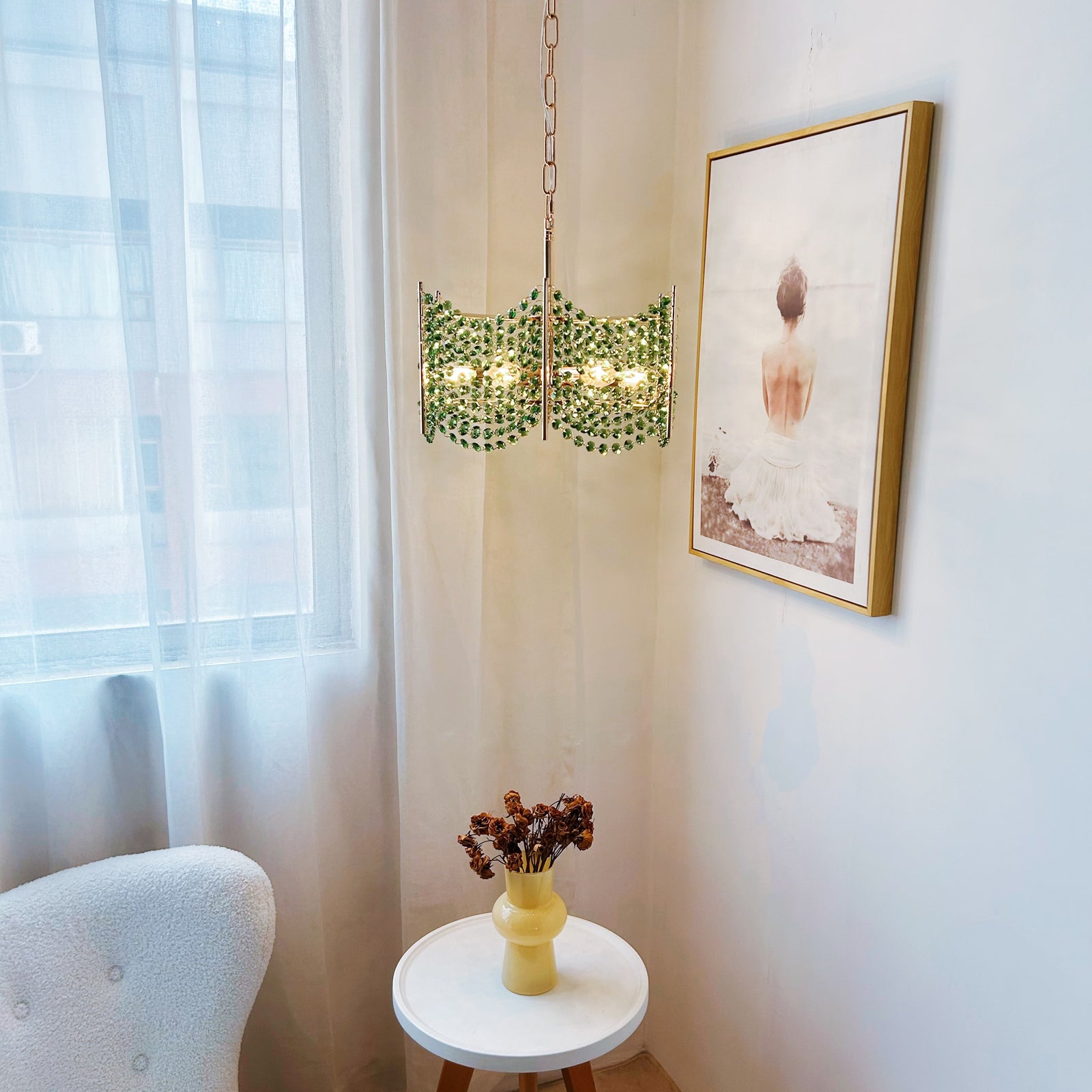 Modern interior with a decorative light fixture, framed artwork, and a small table 