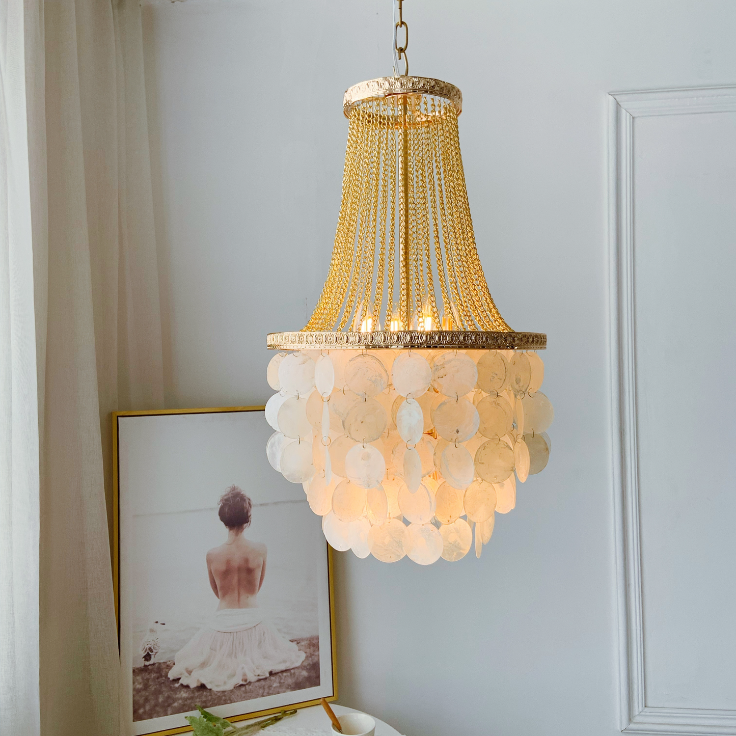 Two tier capiz shell chandelier with French gold finish creating elegant lighting in dining room