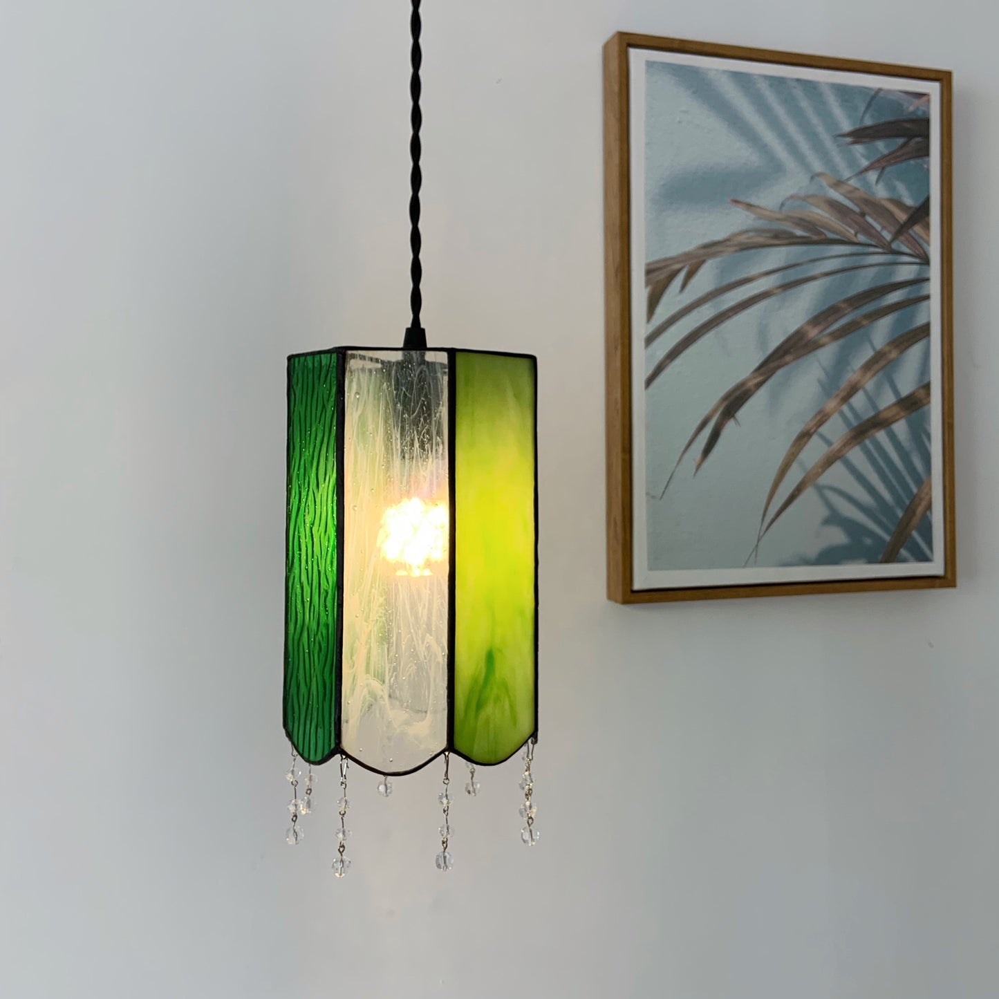 Vintage Tiffany pendant with green art glass creating warm ambient lighting over dining table