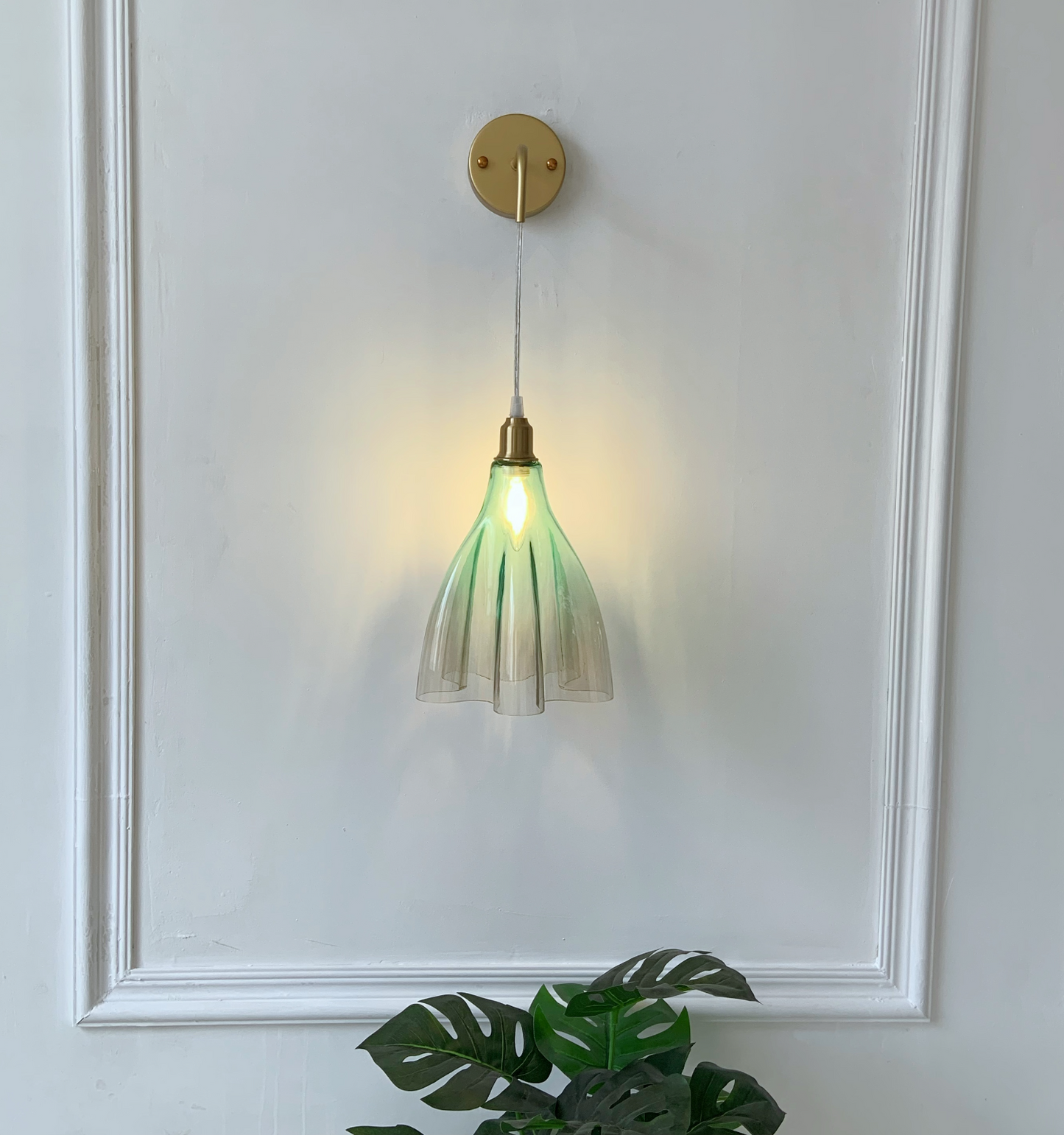 Vintage green ruffled glass sconce with brass finish creating romantic ambient lighting