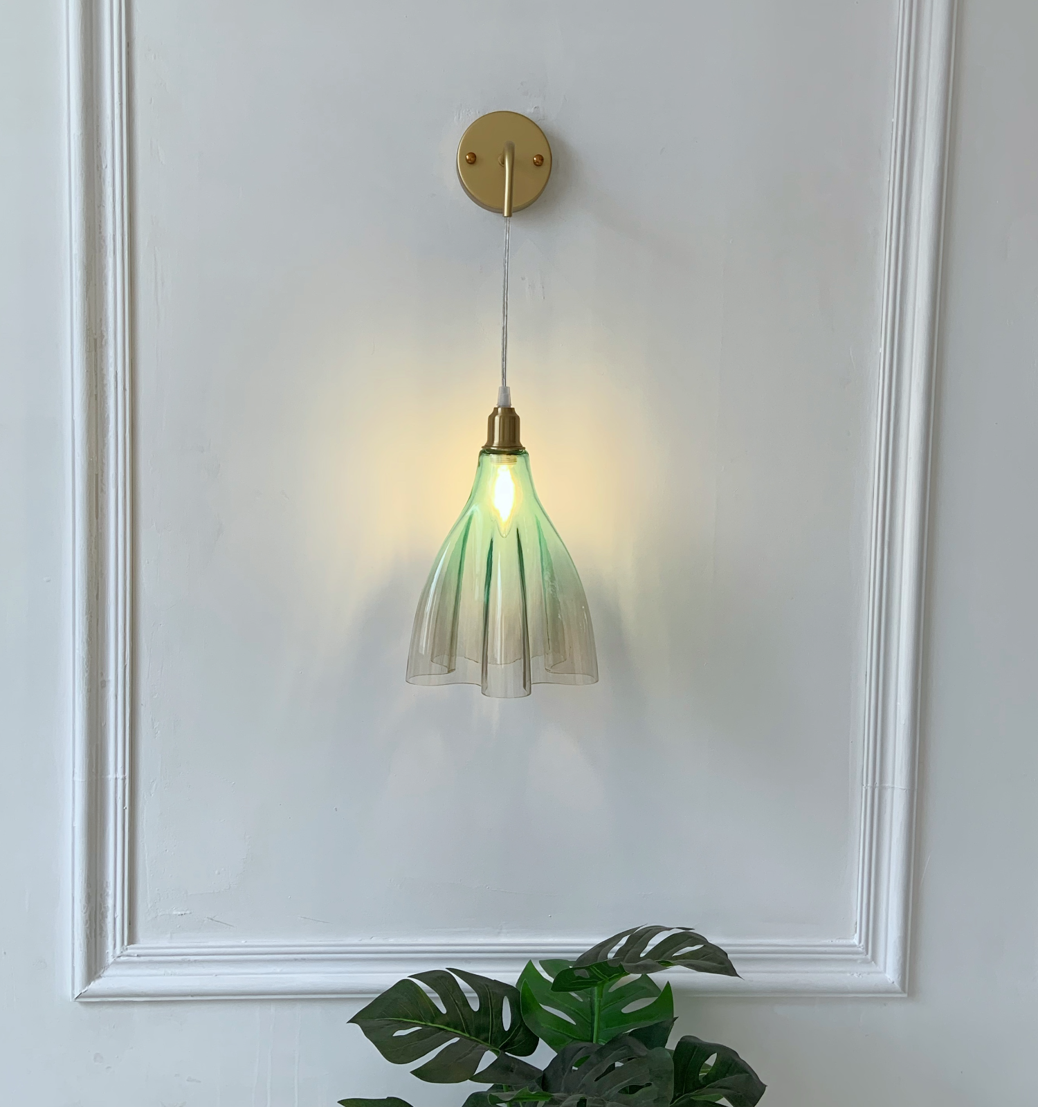 Vintage green ruffled glass sconce with brass finish creating romantic ambient lighting