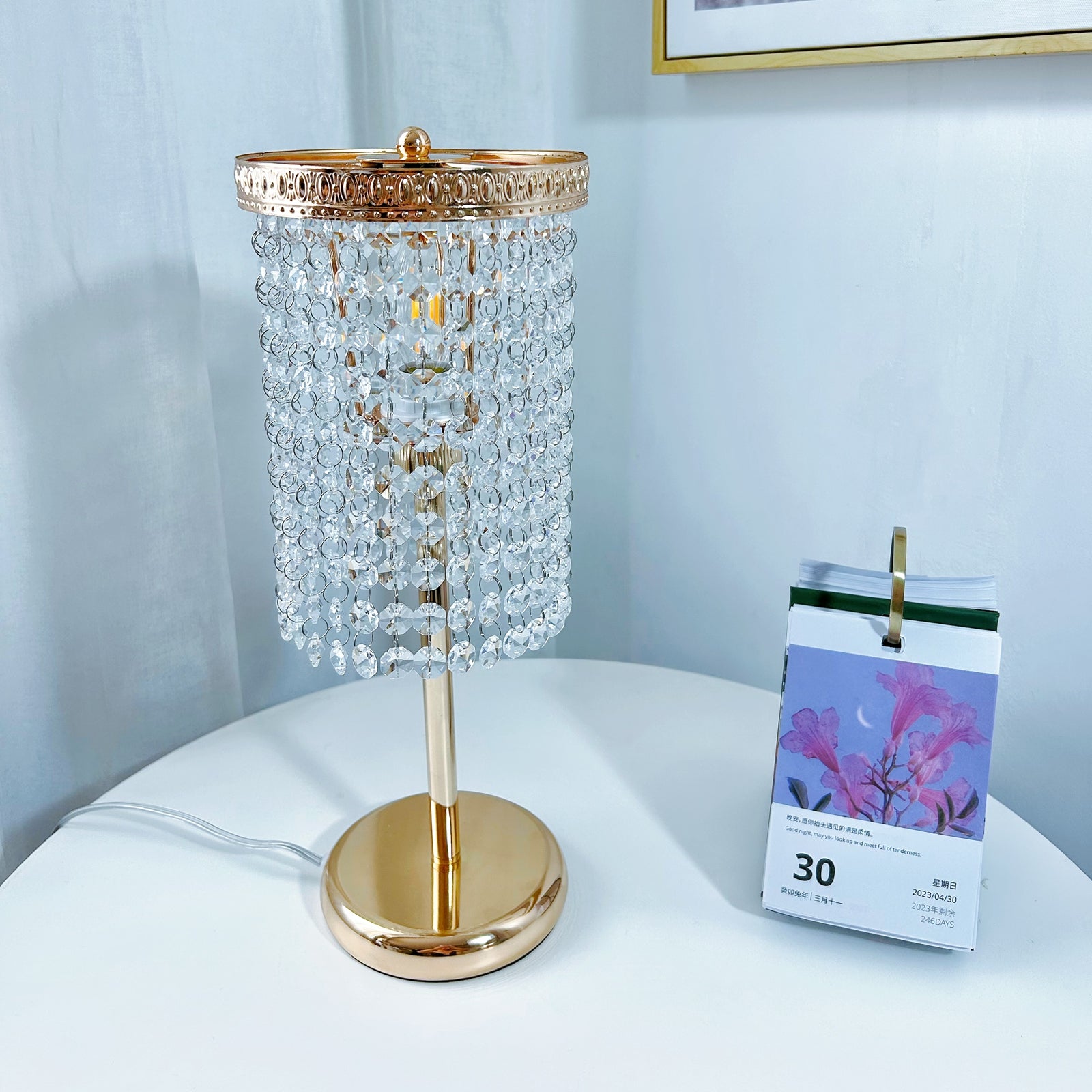 Crystal table lamp with warm gold finish creating ambient lighting in bedroom