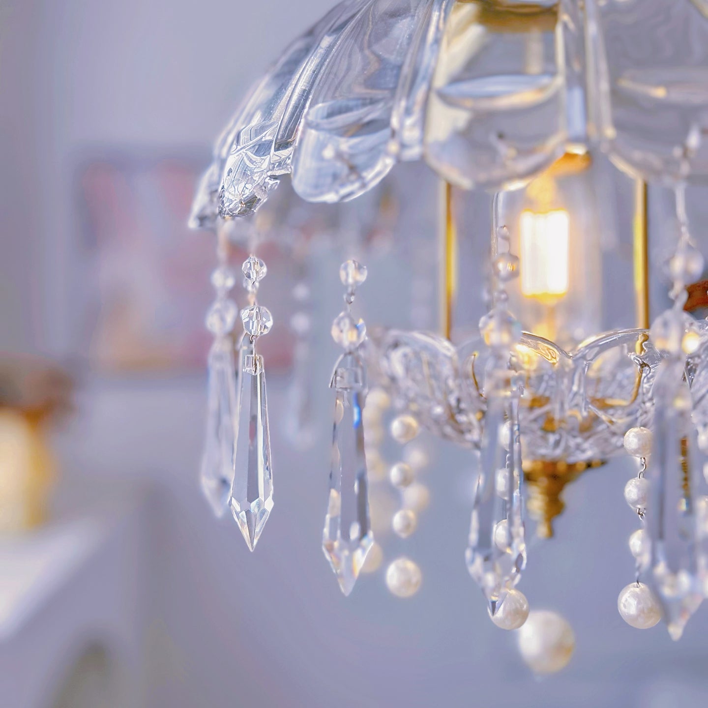 Small crystal chandelier close up showing brass hardware and sparkling crystal details