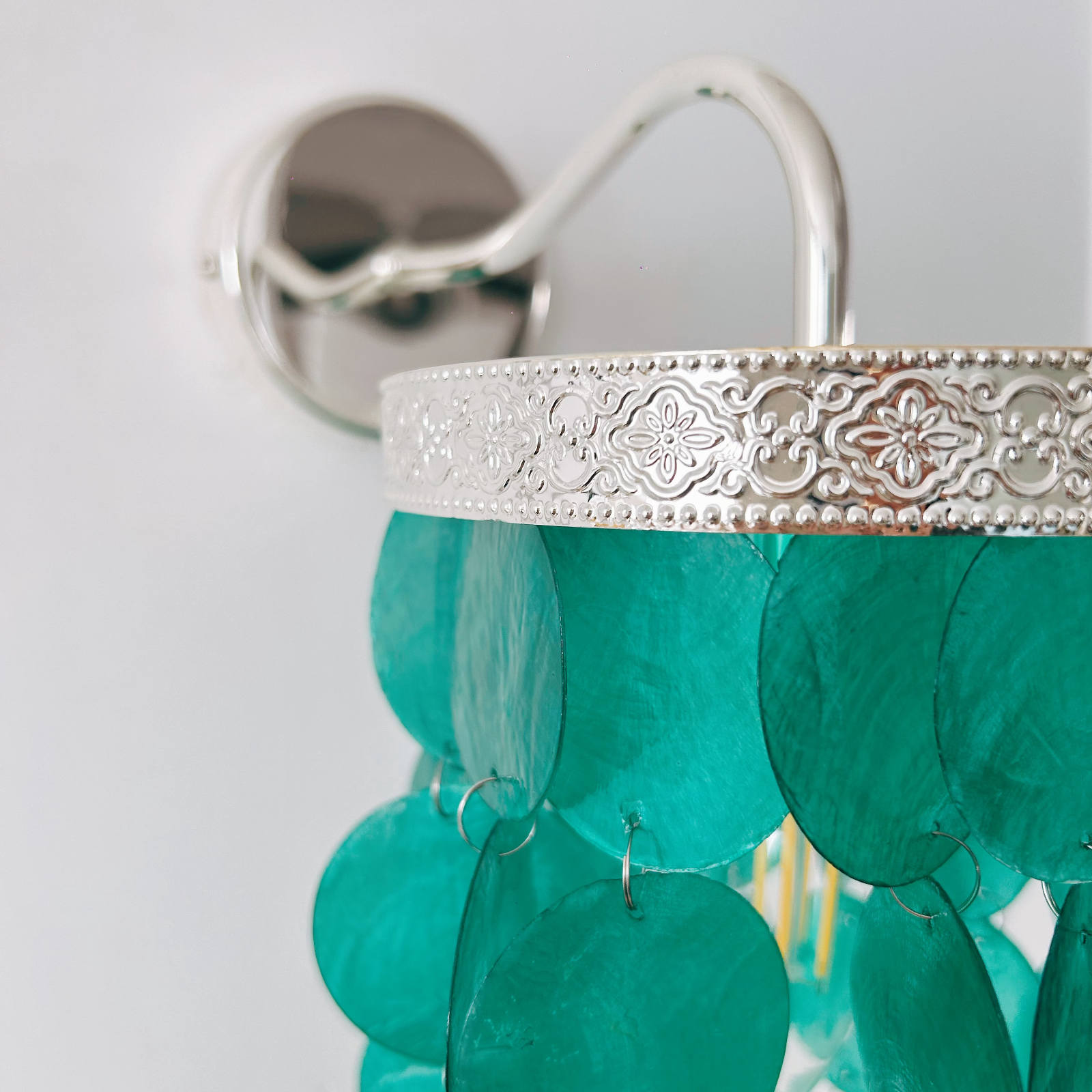 Handcrafted seashell sconce with mother of pearl creating soft ambient lighting in bathroom