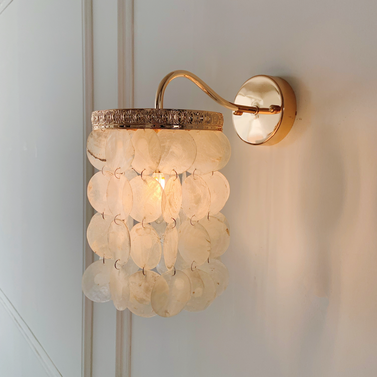 Handcrafted blue capiz shell wall light with French gold creating ocean inspired lighting