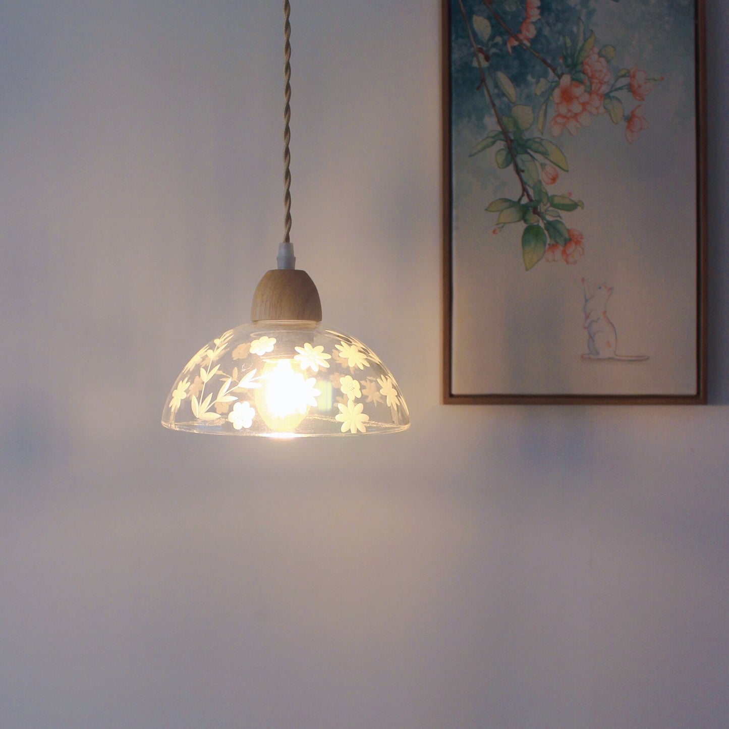 Modern glass pendant light hanging over kitchen island with Edison bulb