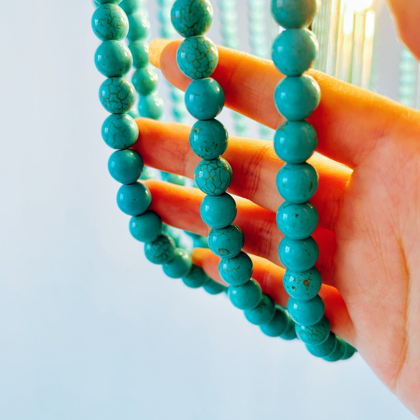 Turquoise beaded bracelets on a hand