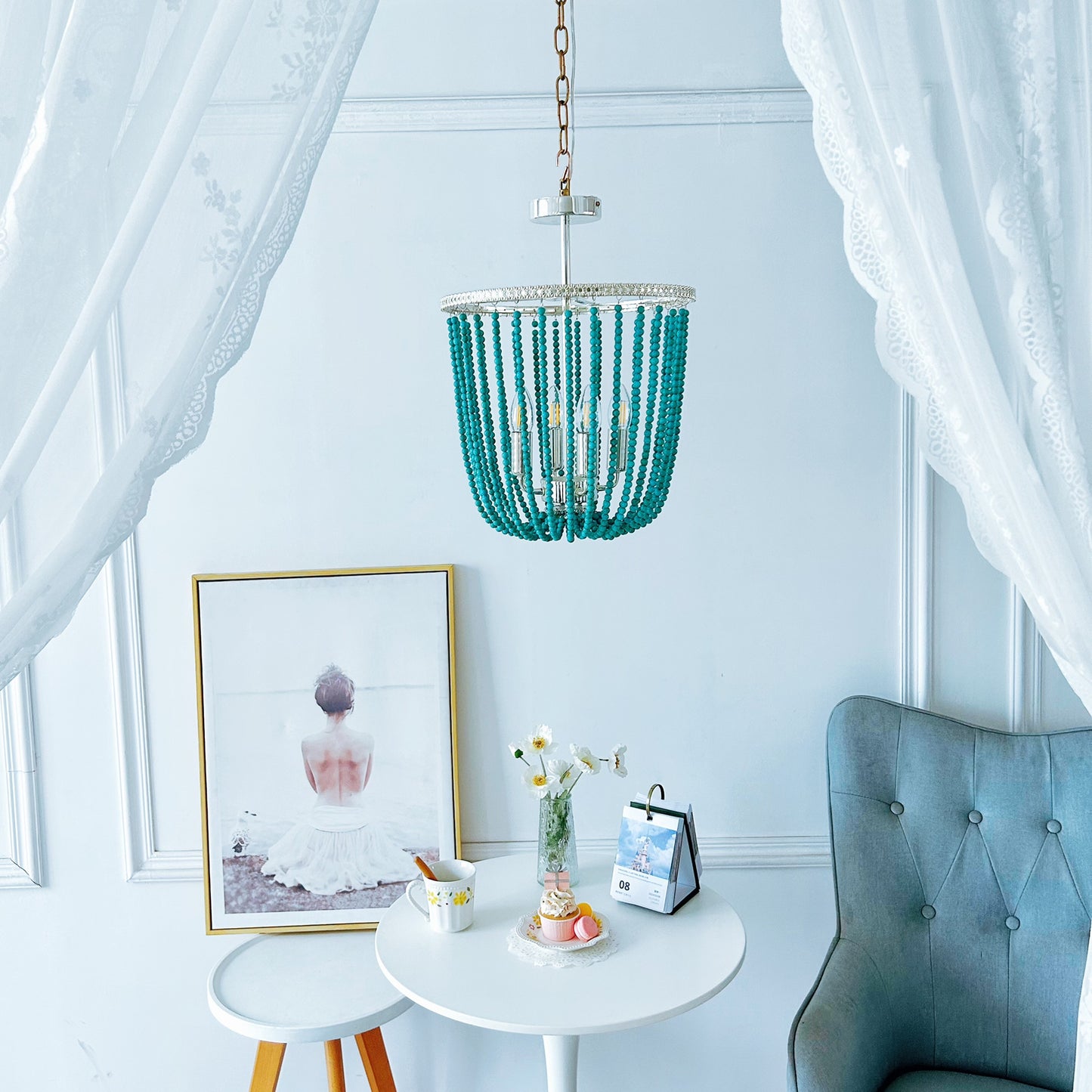 Turquoise beaded chandelier hanging above a small round table with decor items