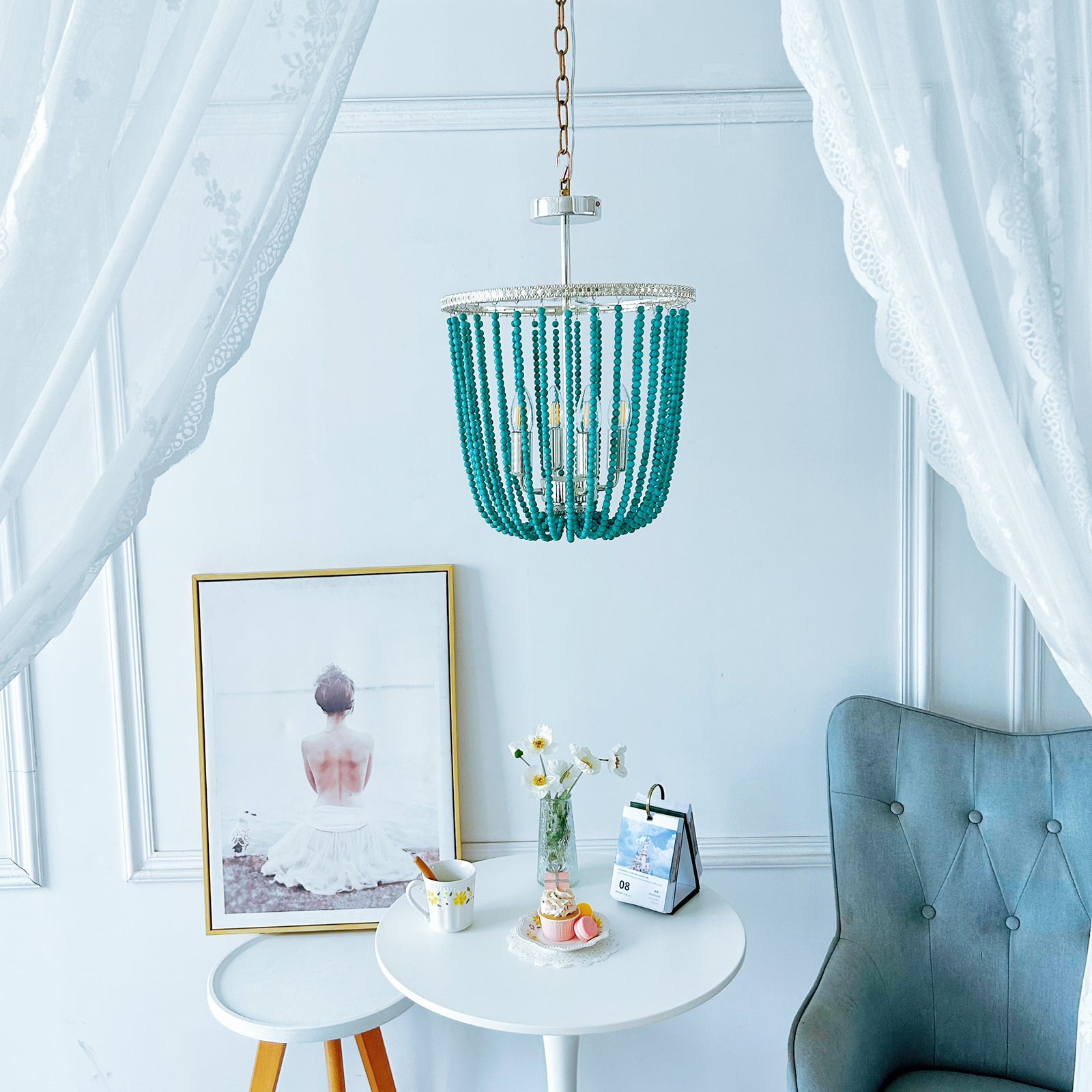 Turquoise beaded chandelier hanging above a small round table with decor items