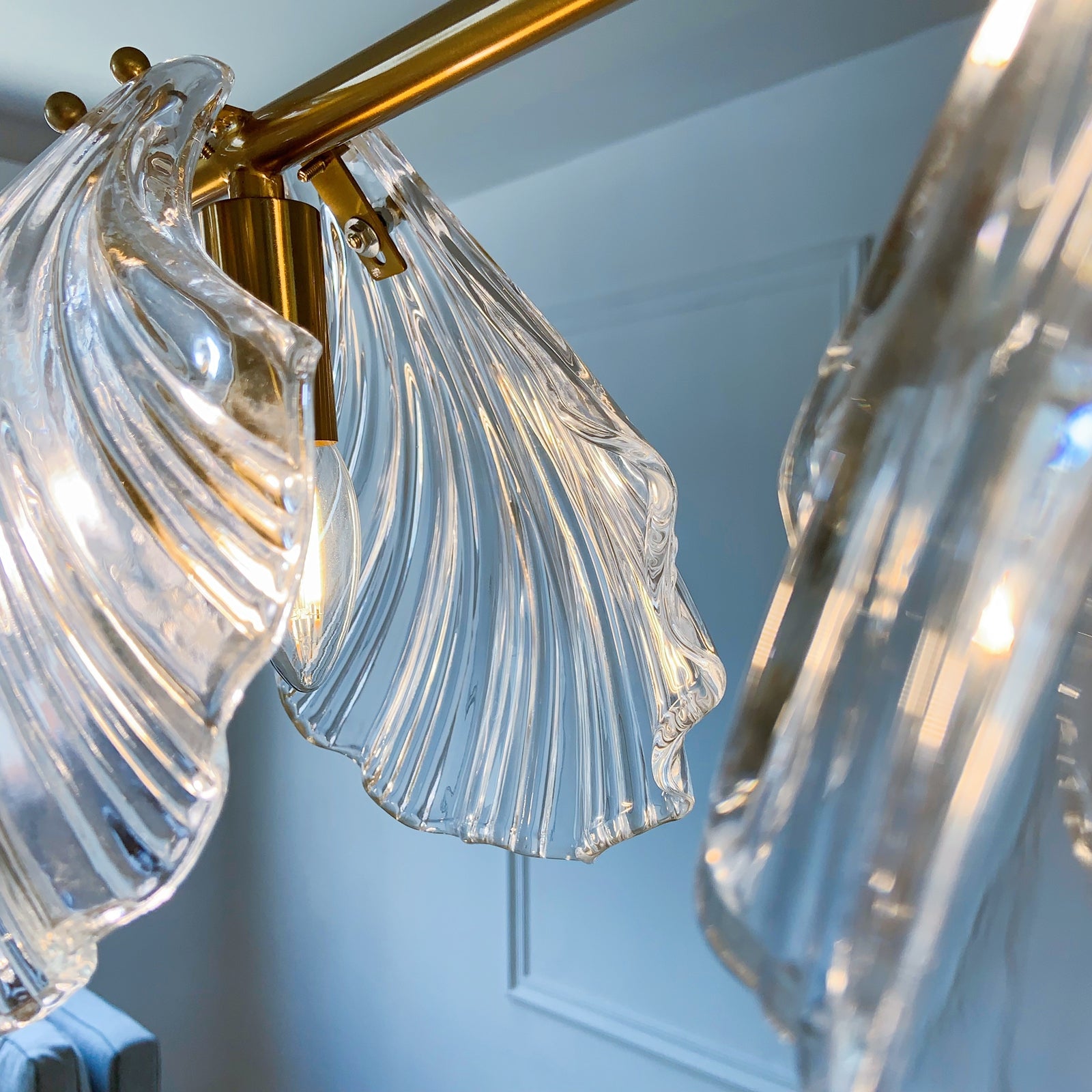 Close-up of a modern chandelier with clear glass shades and gold metal fixture 