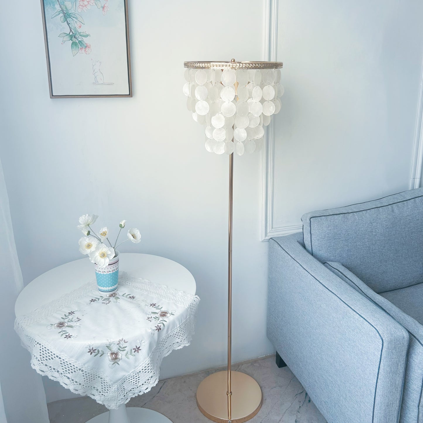 Living room with a floor lamp, round table, and gray sofa.