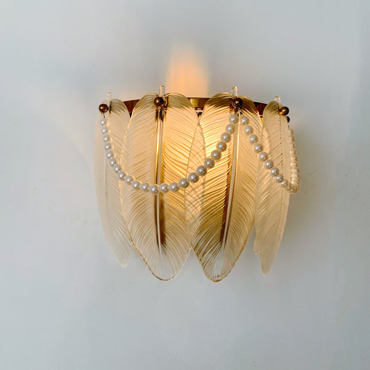 Decorative wall light fixture with leaf-like design and pearl chain