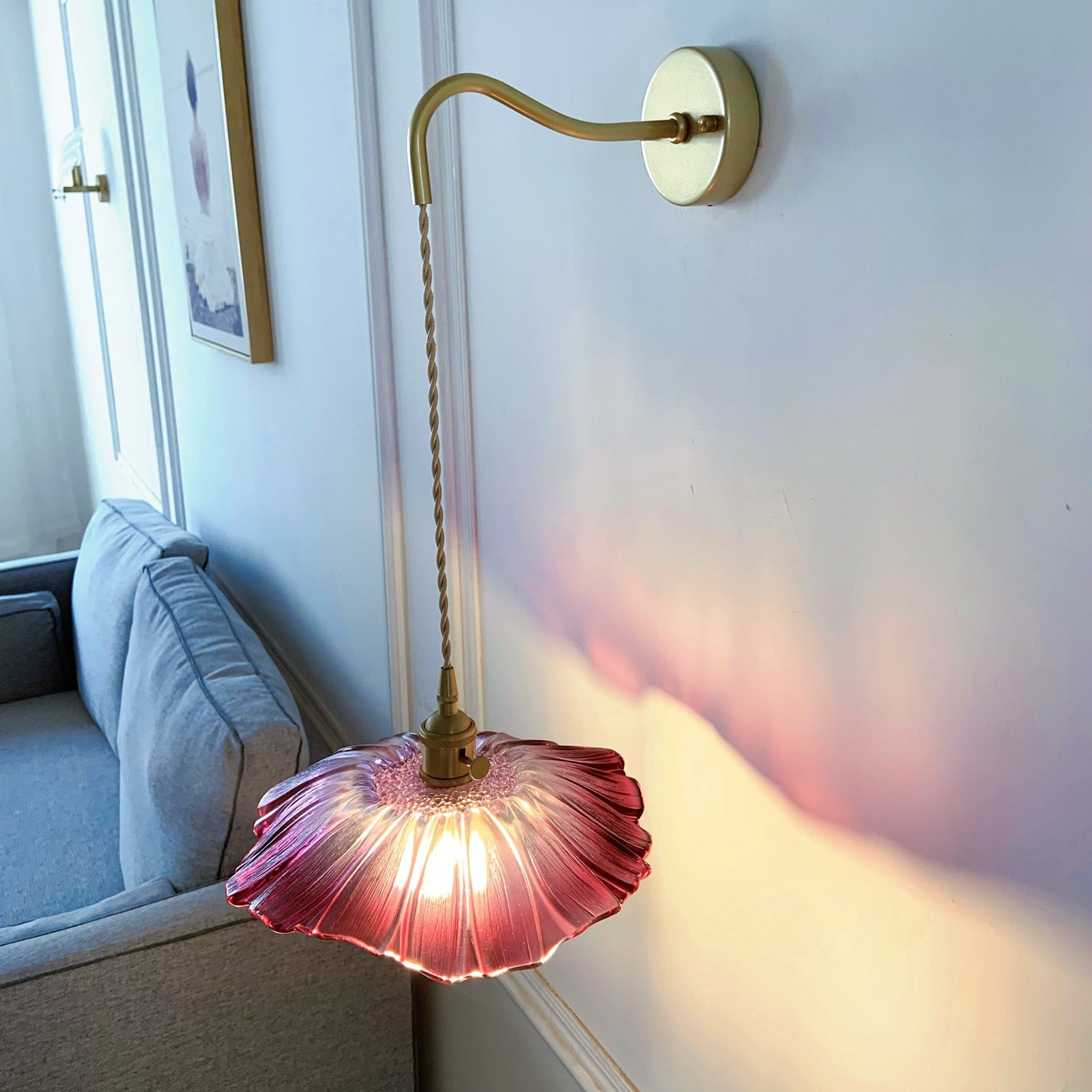 Glass wall sconce close up showing brass hardware and clear glass shade details