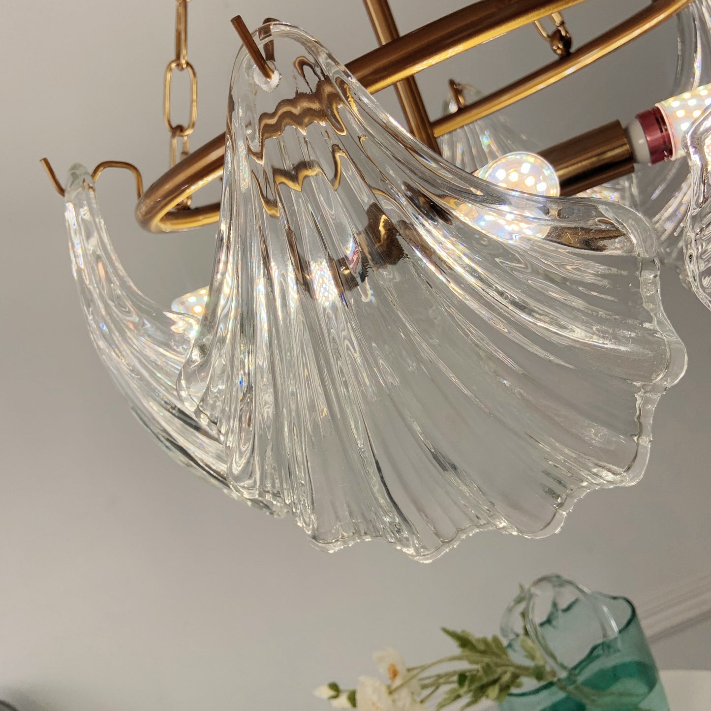 Chandelier with clear glass shades and gold metal accents on a neutral background