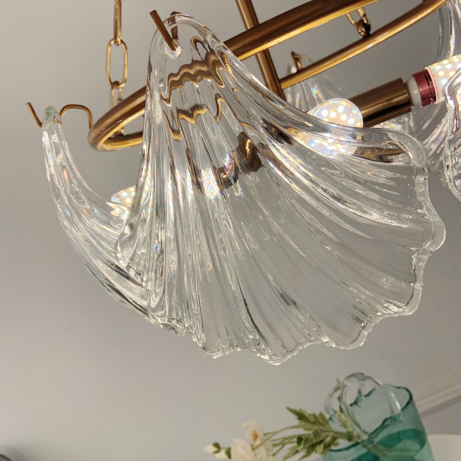 Chandelier with clear glass shades and gold metal accents on a neutral background