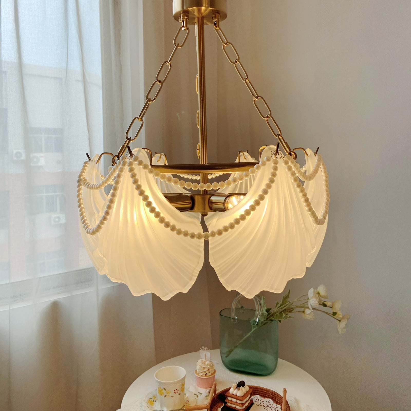 Decorative chandelier with scalloped glass shades in a room setting.