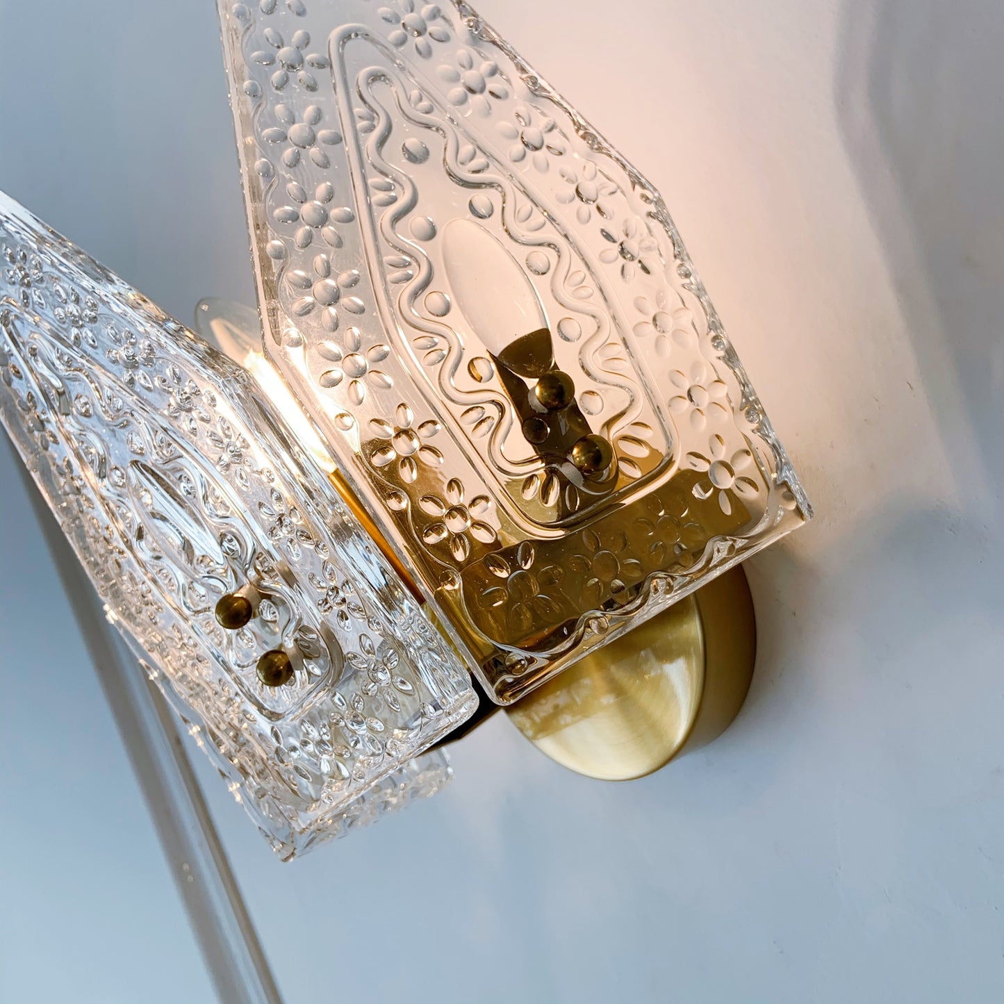 Close-up detail of brass crown design on glass wall light - premium handcrafted sconce