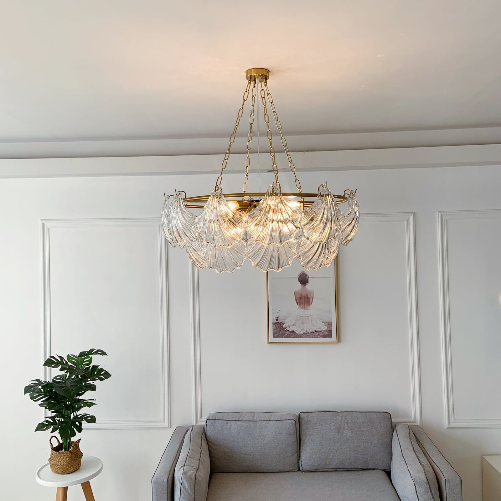 Chandelier hanging above a gray sofa in a living room