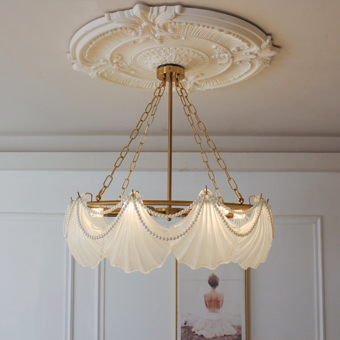 Decorative ceiling light fixture with shell-shaped lampshades in a room setting.