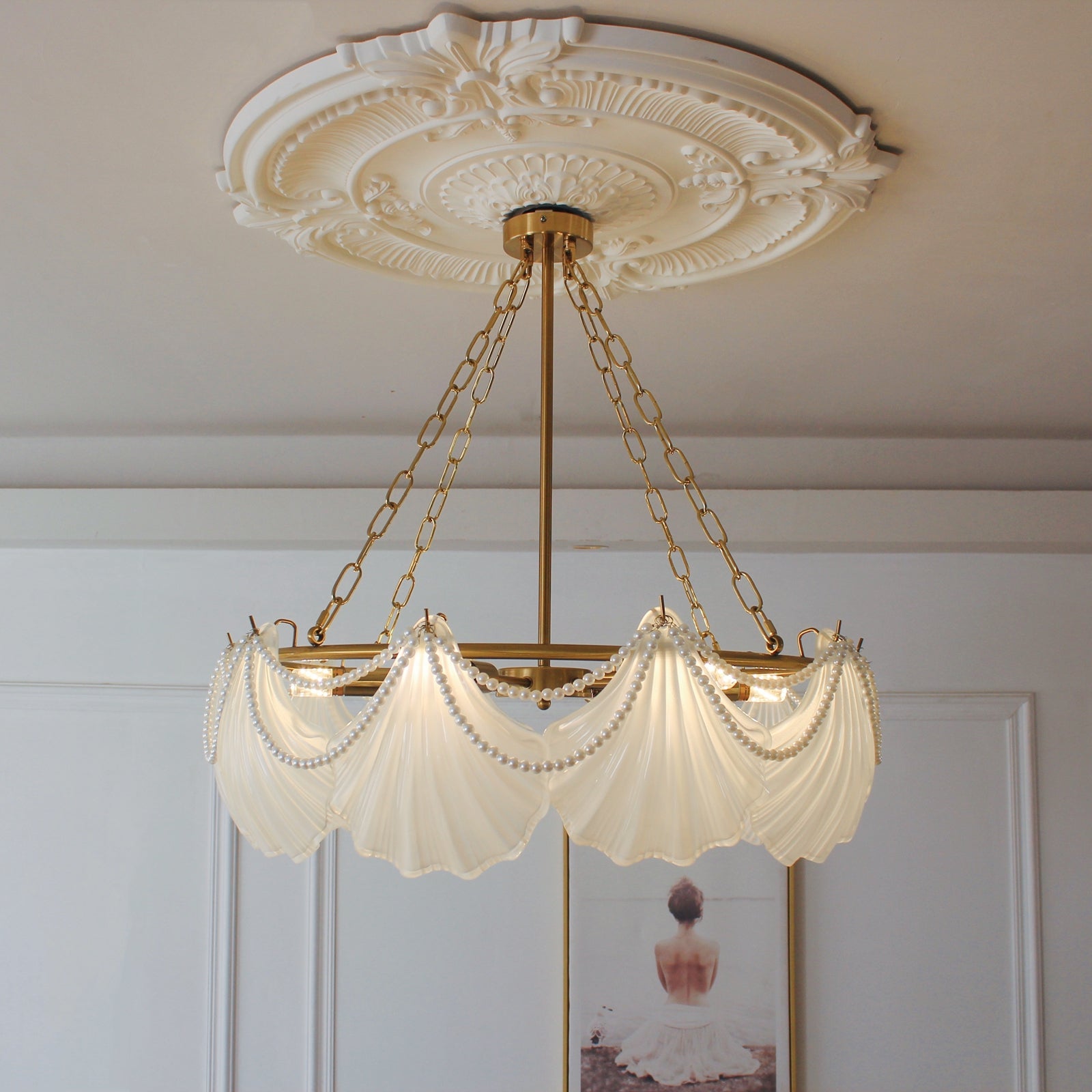 Decorative ceiling light fixture with shell-shaped lampshades in a room setting.