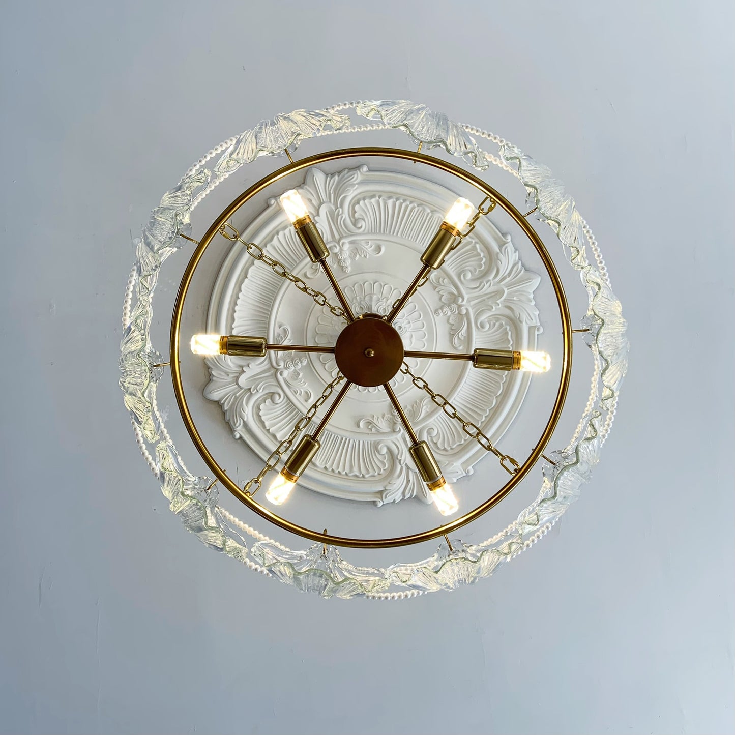 Decorative ceiling light fixture with gold accents on a white ceiling.