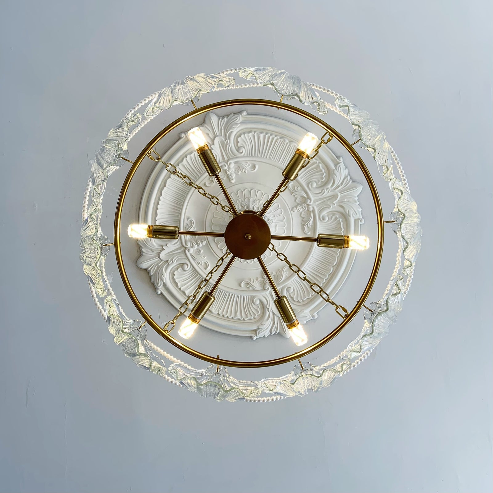 Decorative ceiling light fixture with gold accents on a white ceiling.