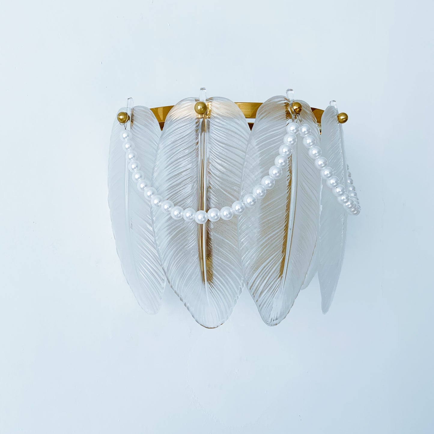 Decorative wall light fixture with feather-like design and pearl accents 