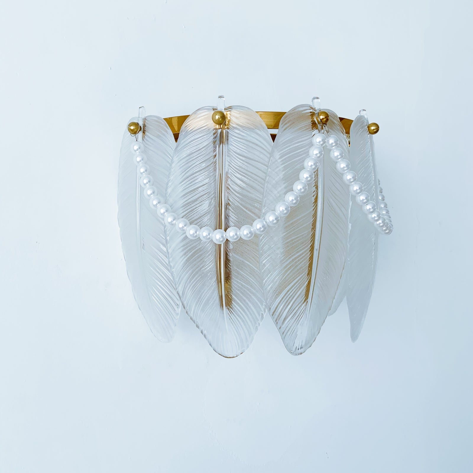 Decorative wall light fixture with feather-like design and pearl accents 