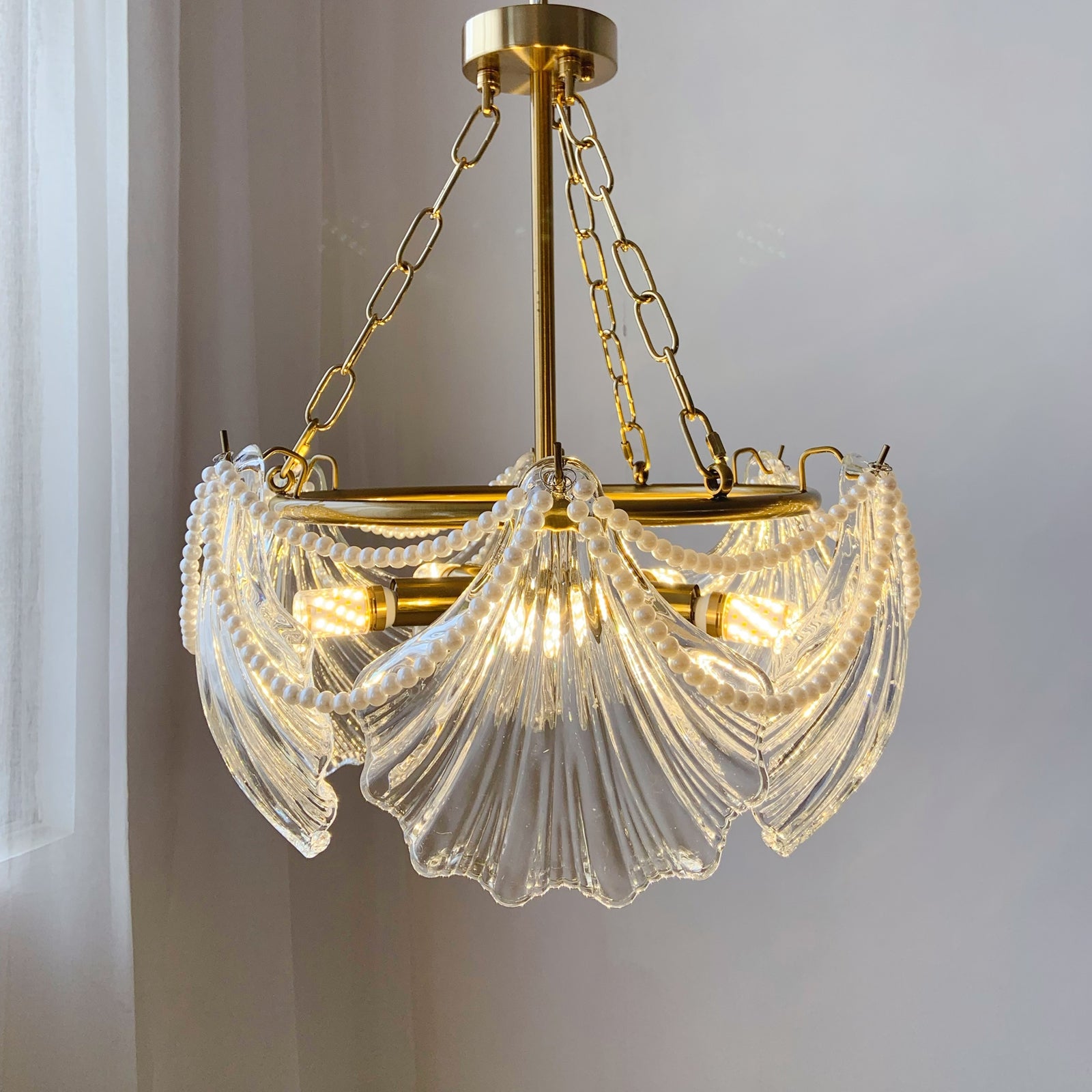 Gold chandelier with clear glass shades on a neutral background