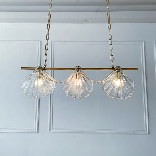 Chandelier with shell-shaped glass lights on a white paneled wall