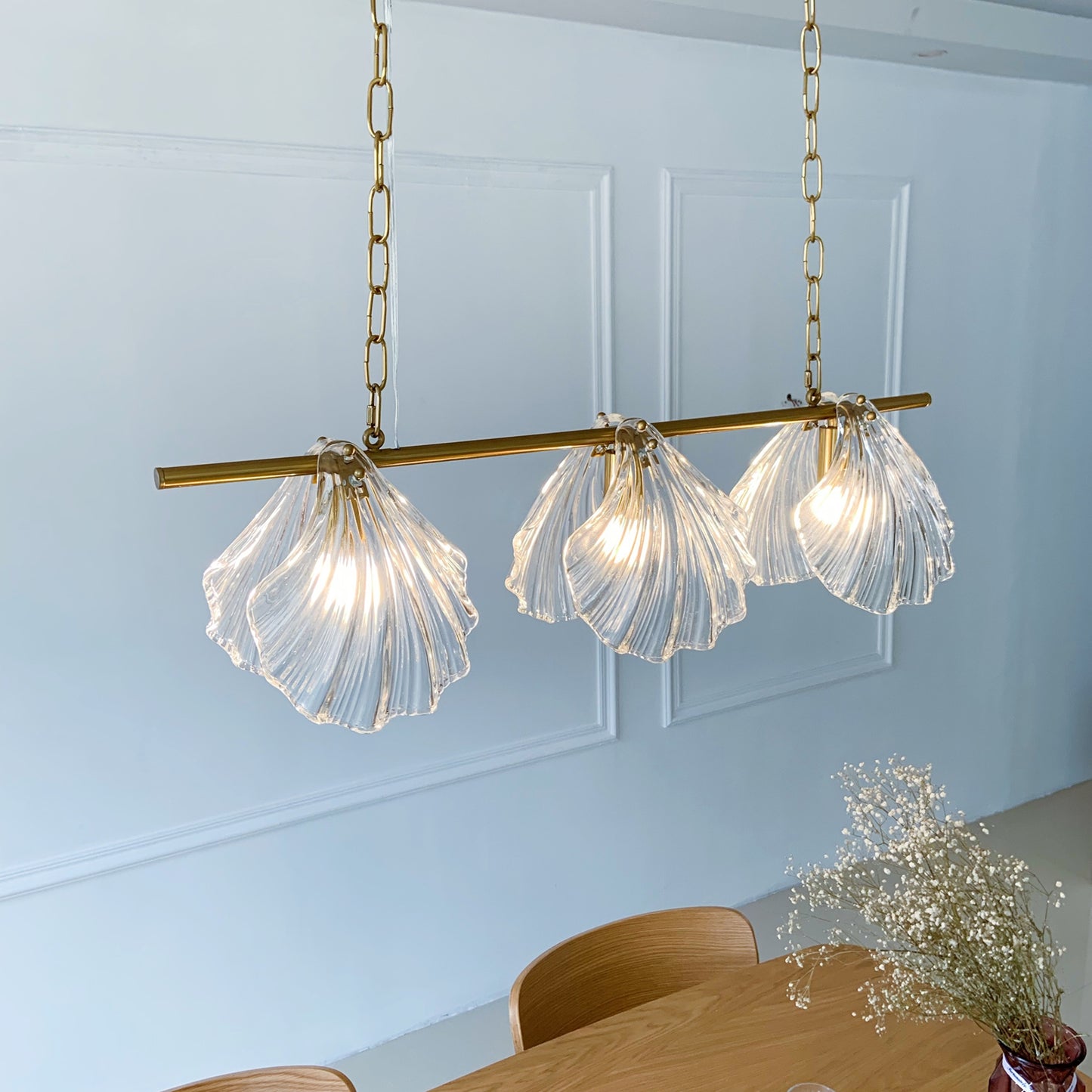 Modern pendant light fixture with glass shades hanging above a dining table.