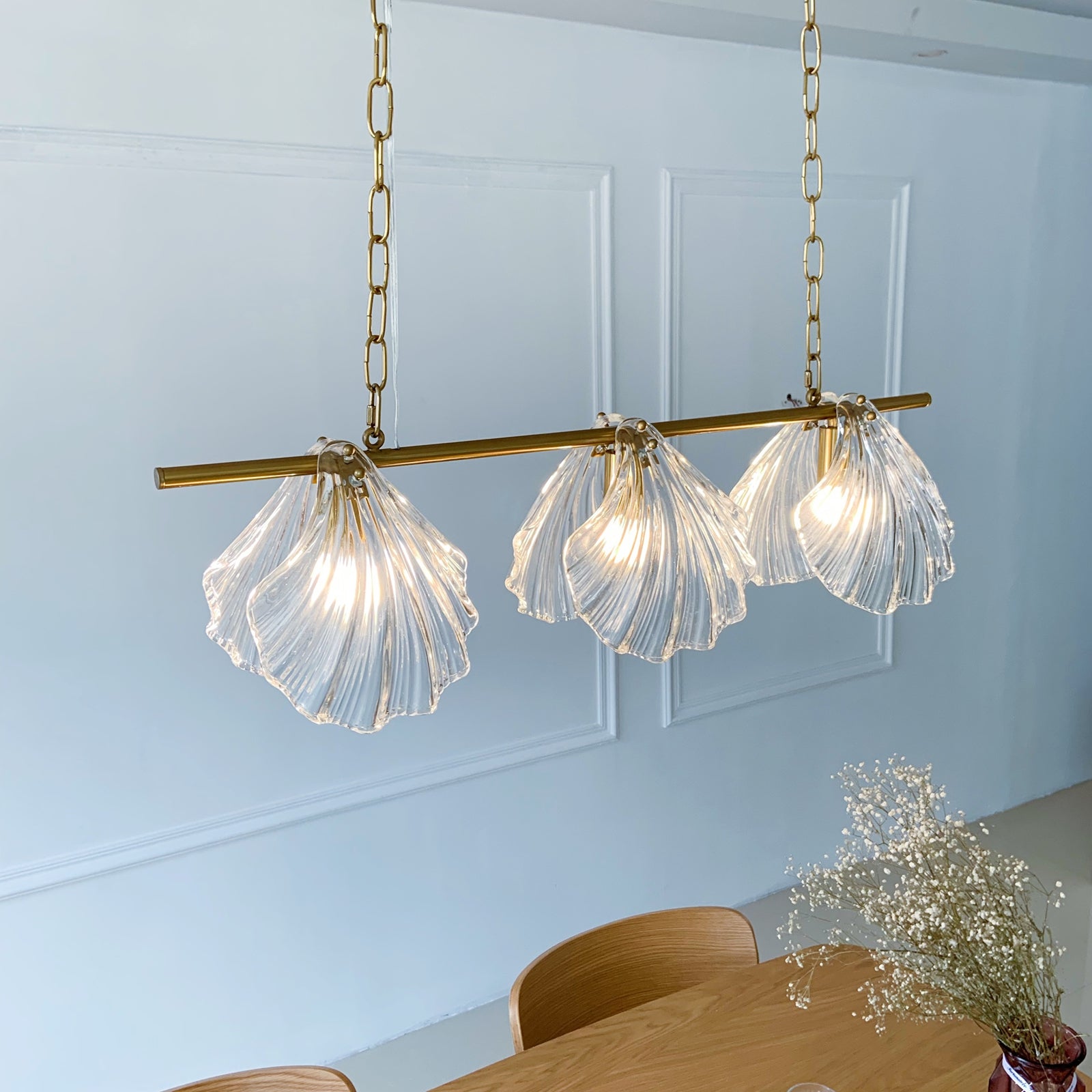 Modern pendant light fixture with glass shades hanging above a dining table.