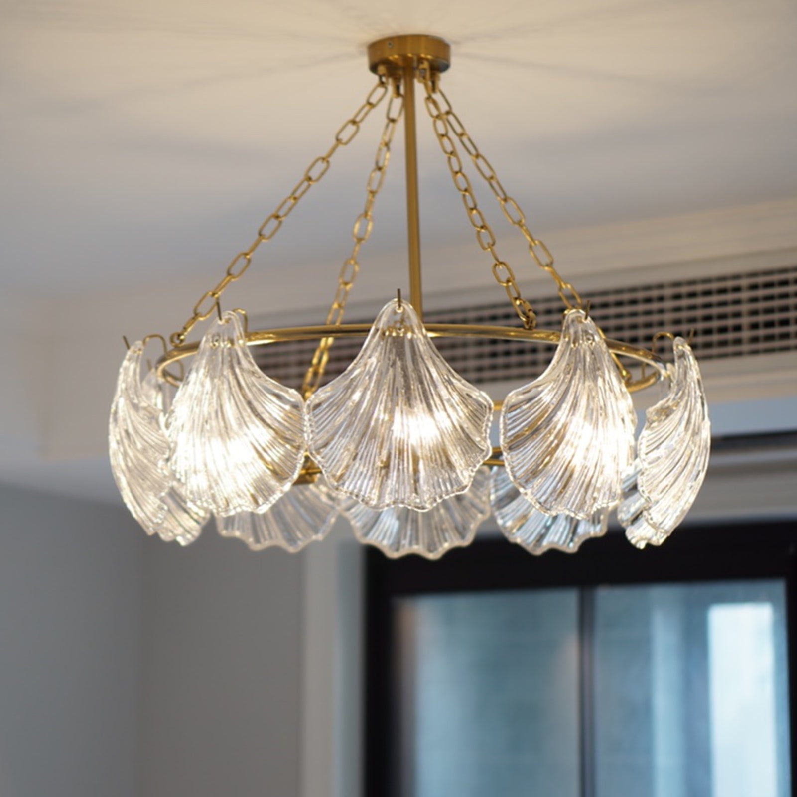 Chandelier with glass shades and gold frame hanging from ceiling
